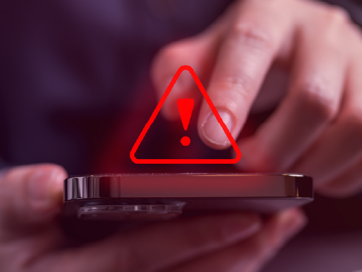 red alert symbol over a mobile phone