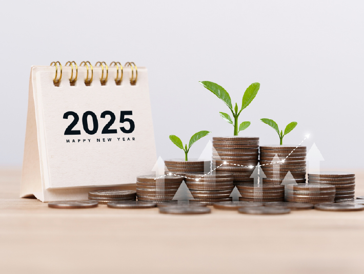 2025 calendar next to stacks of coins with green plant shoots on top